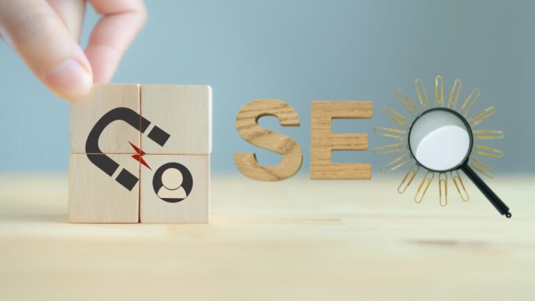 The image shows a hand arranging wooden blocks with a magnet icon and the letters "SEO" to represent the connection between Inbound Marketing and SEO