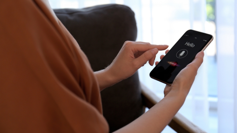 A person uses a smartphone voice assistant, showing the need to create voice search SEO content that ranks