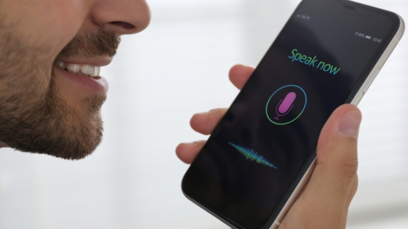 A man speaks into his smartphone voice assistant