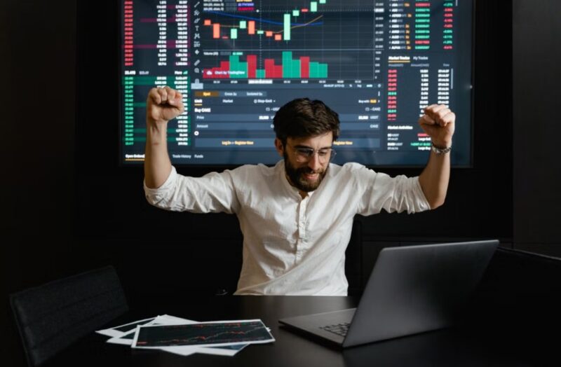 A businessman raising his hands for being successful