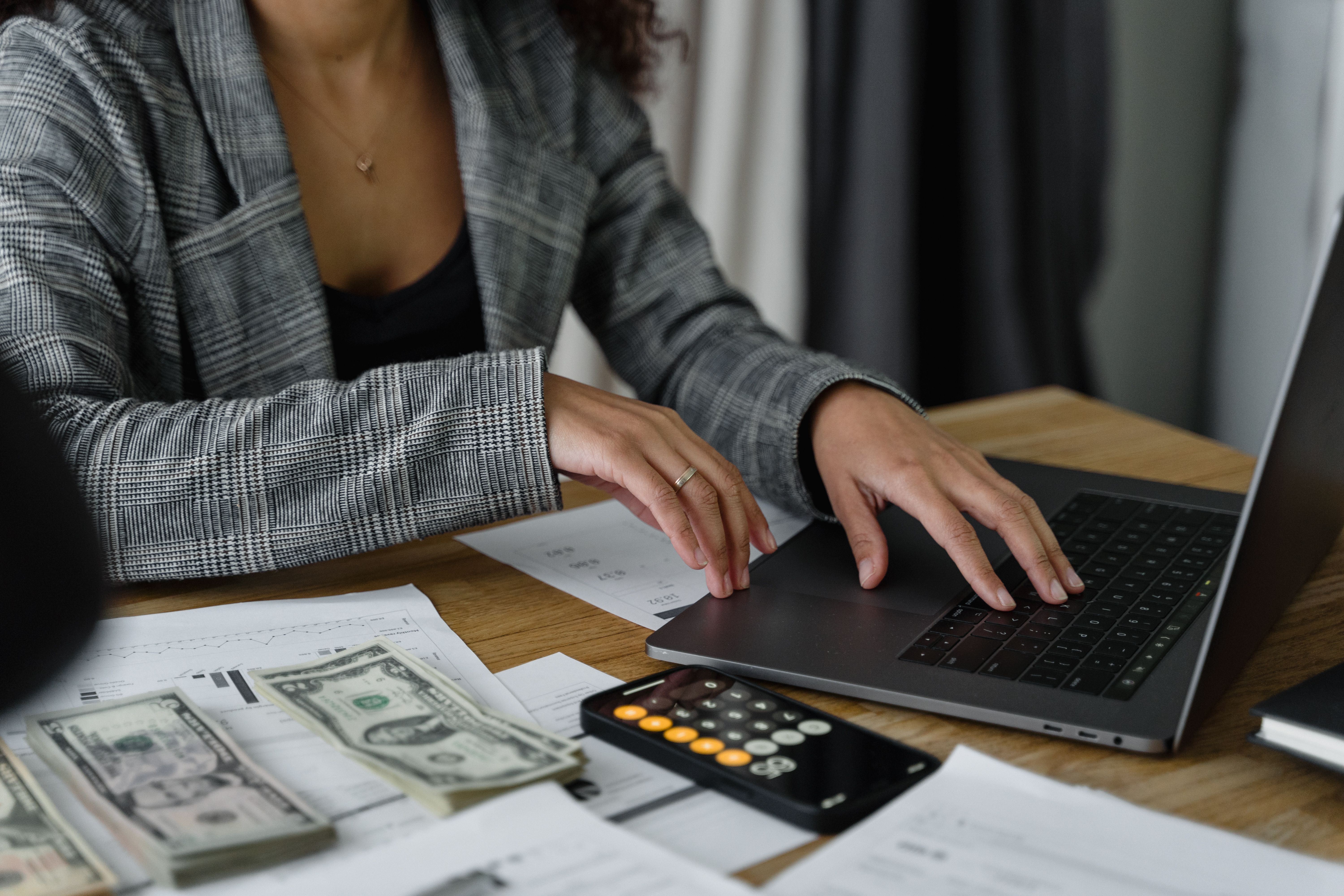 Businesswoman reviewing financial figures with a calculator, representing a practical look at account costs and features.